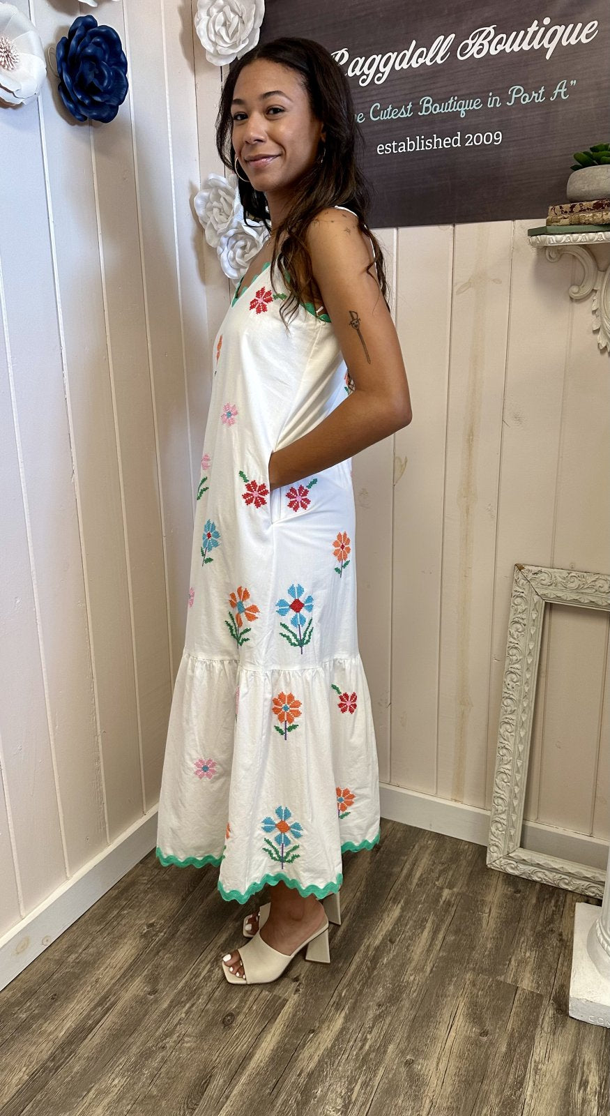 Teagan Dress in white with colorful floral embroidery, perfect for summer beach vibes; available at a coastal boutique.
