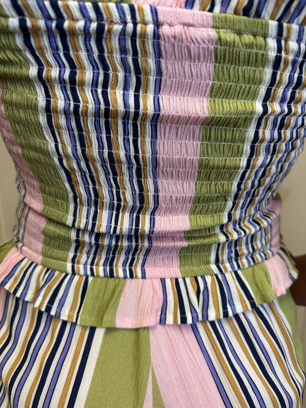 Close-up of Lori Romper's smocked bodice in pink and green stripes, perfect for coastal boutique clothing and tropical vacation wear.