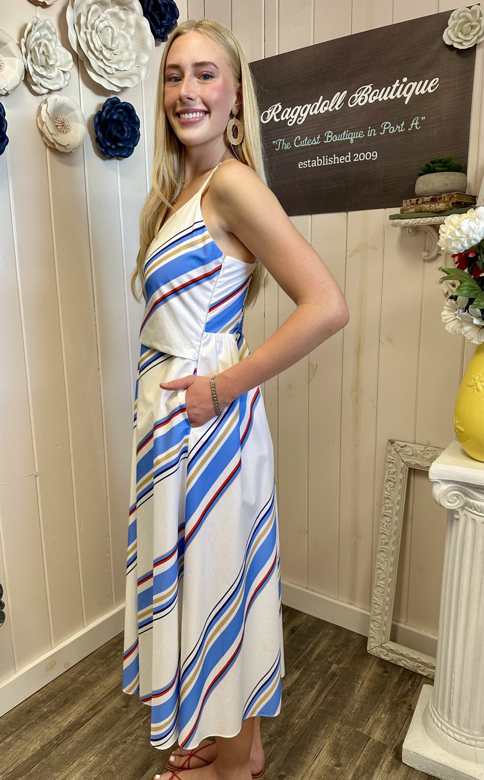 Model wearing Fisher Dress with blue and red stripes, perfect for coastal boutique clothing and summer beach outings.