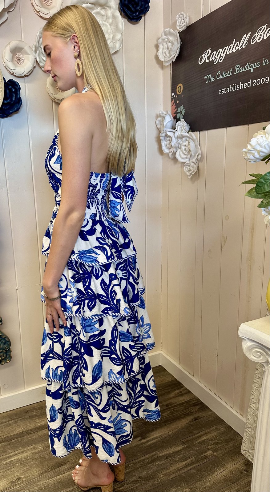 Model wearing a breezy blue paisley midi dress at a coastal boutique, perfect for tropical vacations and summer styles.