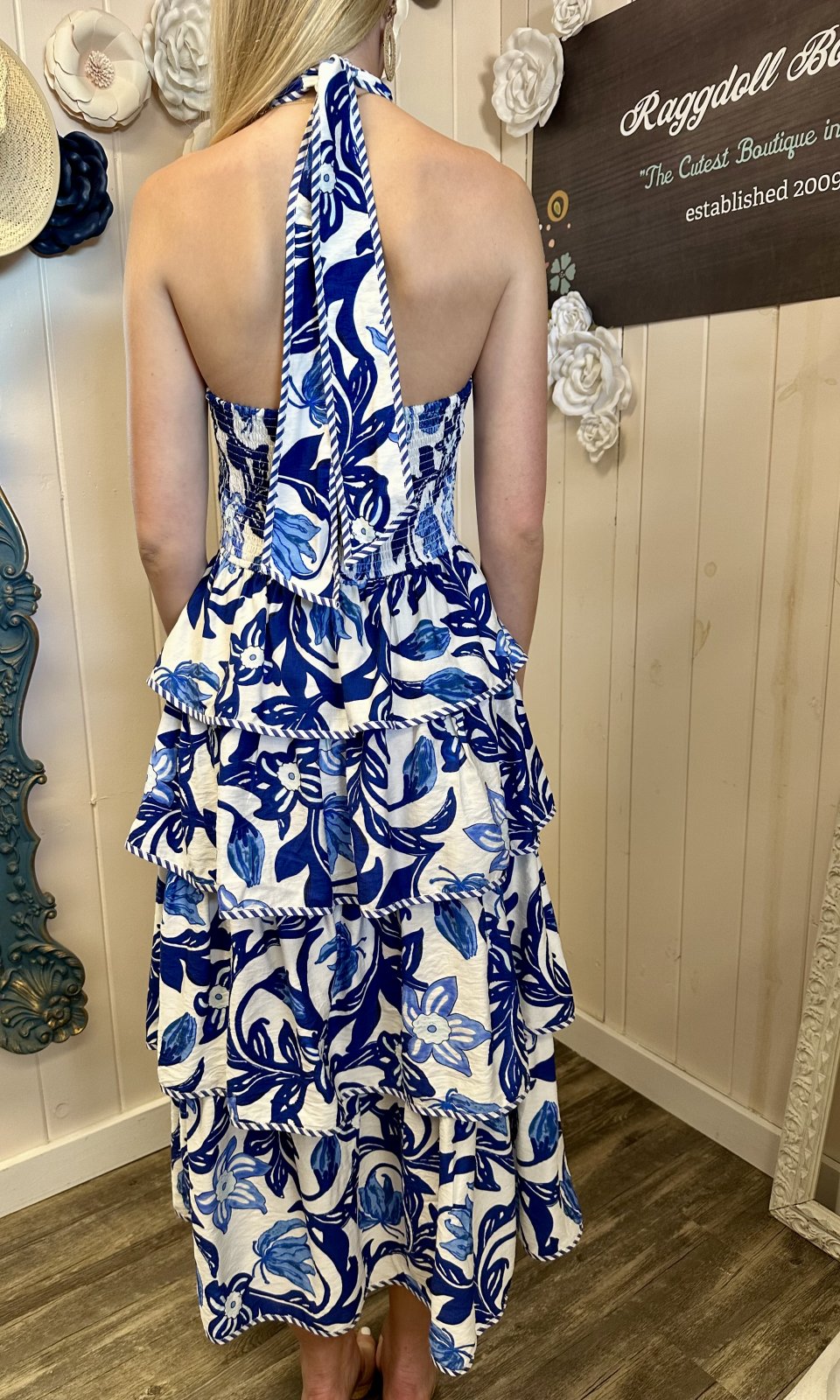 Blue paisley print midi dress with tiered silhouette and bow-tie neckline, ideal for coastal boutique clothing and summer fashion.