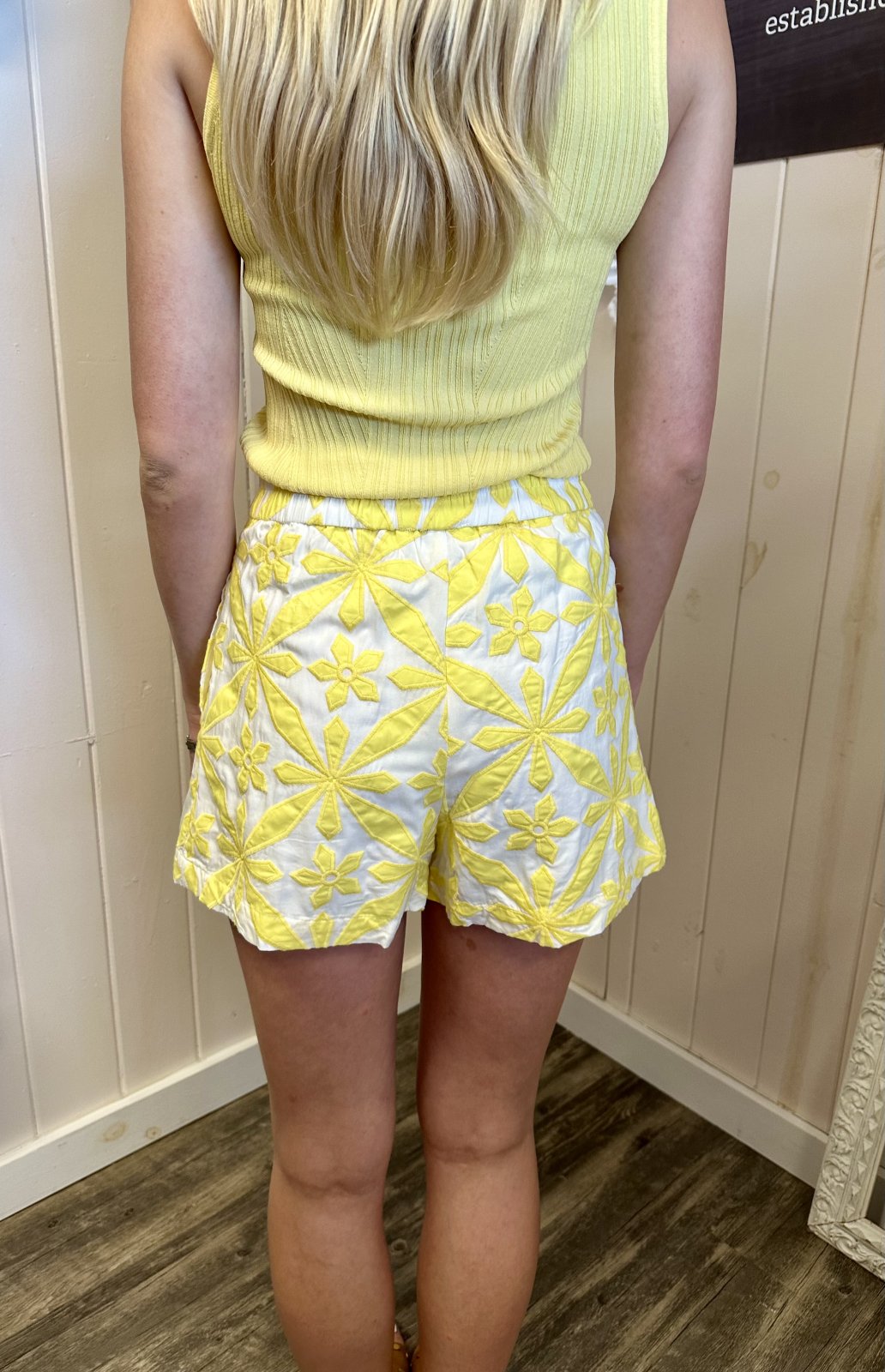 Back view of vibrant yellow embroidered shorts, perfect for coastal boutique clothing and summer beach outings.