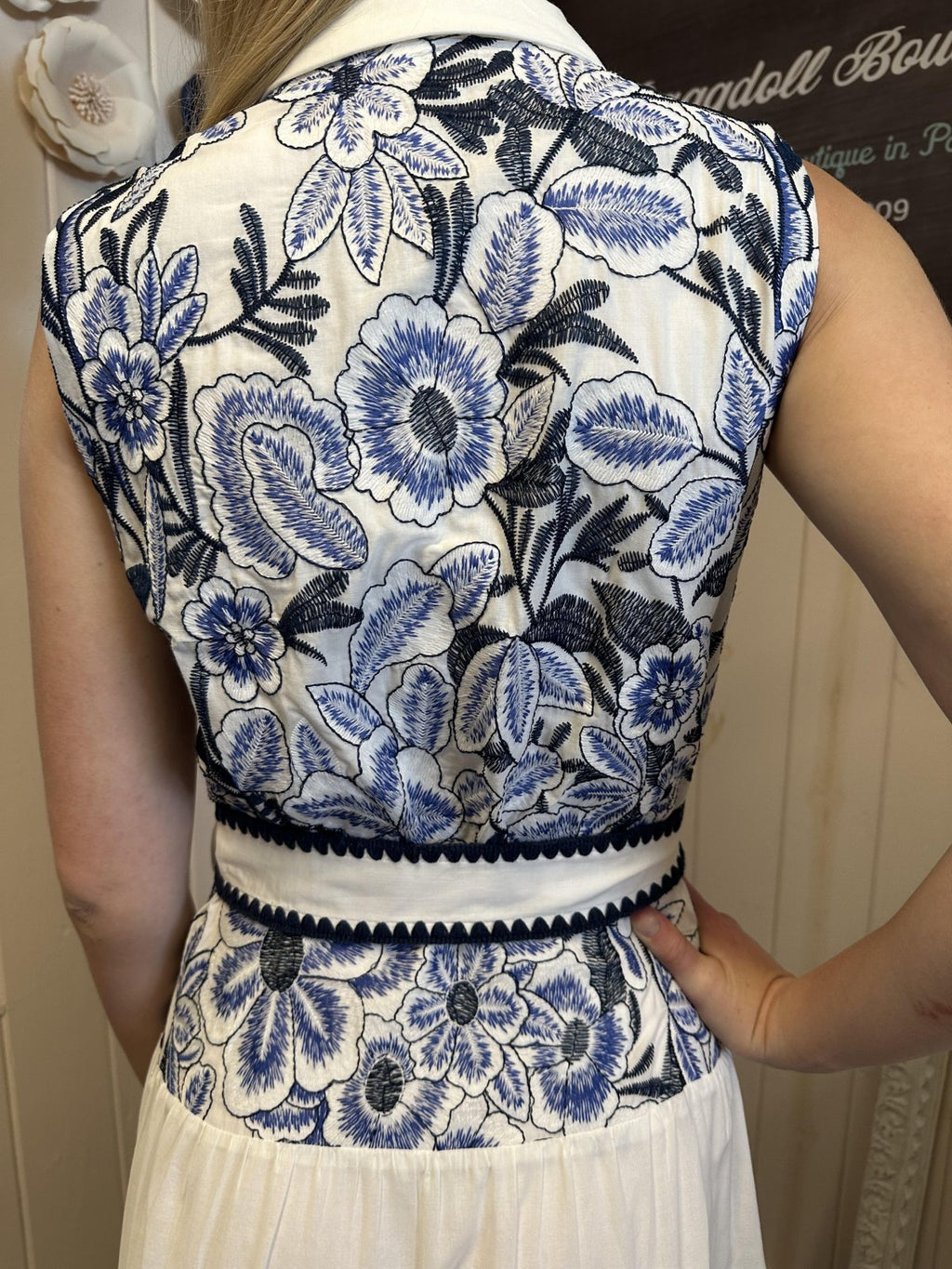 Back view of the Adelyn Dress showcasing blue floral embroidery, perfect for coastal boutique clothing and beach occasions.