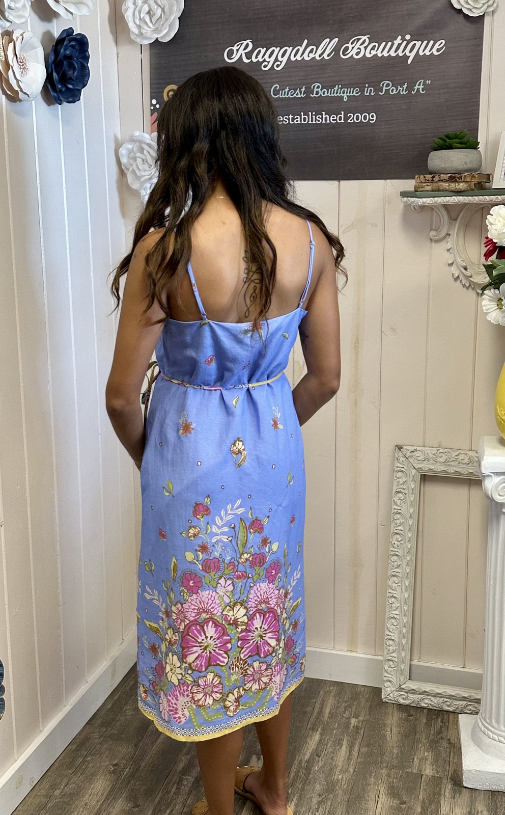 Back view of the Ellison Dress in chambray blue, featuring floral border print, perfect for beach days and casual outings.