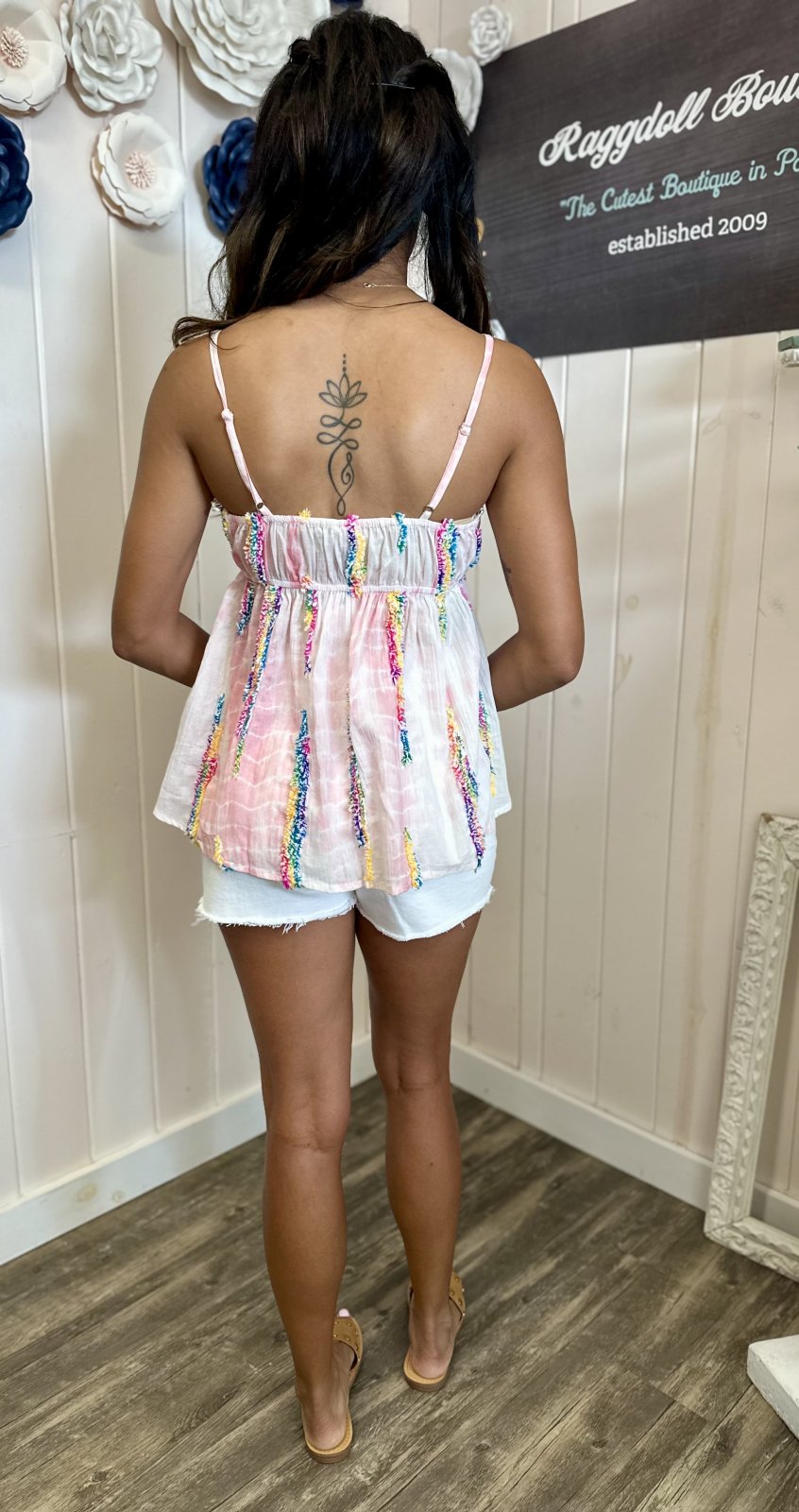Back view of a woman wearing the vibrant Arielle Top from our Port Aransas boutique, perfect for tropical vacations.