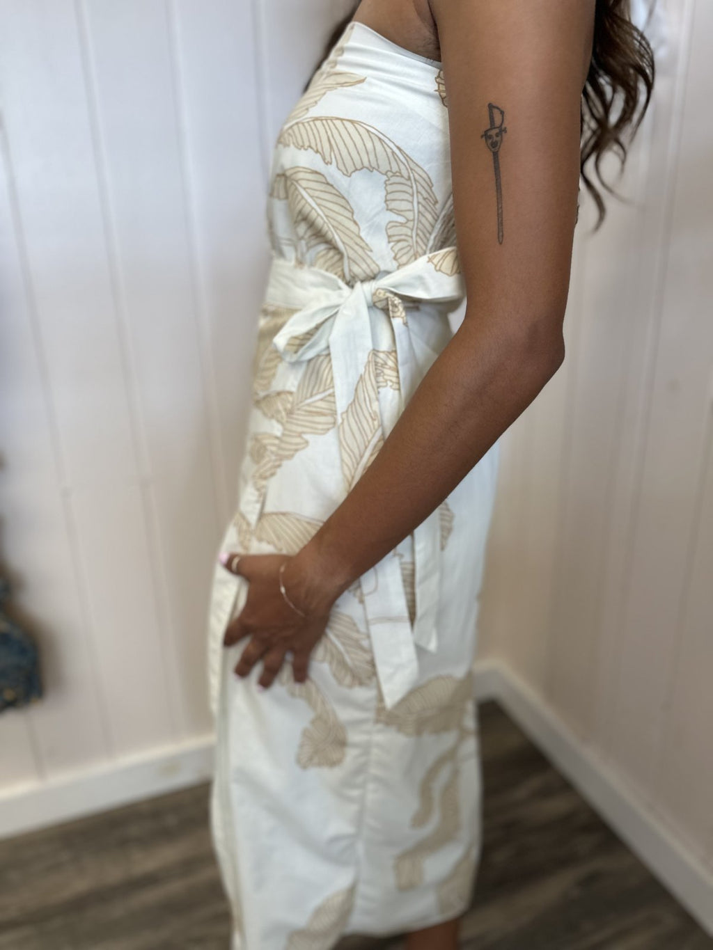 Side view of a stylish strapless white Adele dress with light taupe palm print, perfect for beach outings from a Port Aransas boutique.