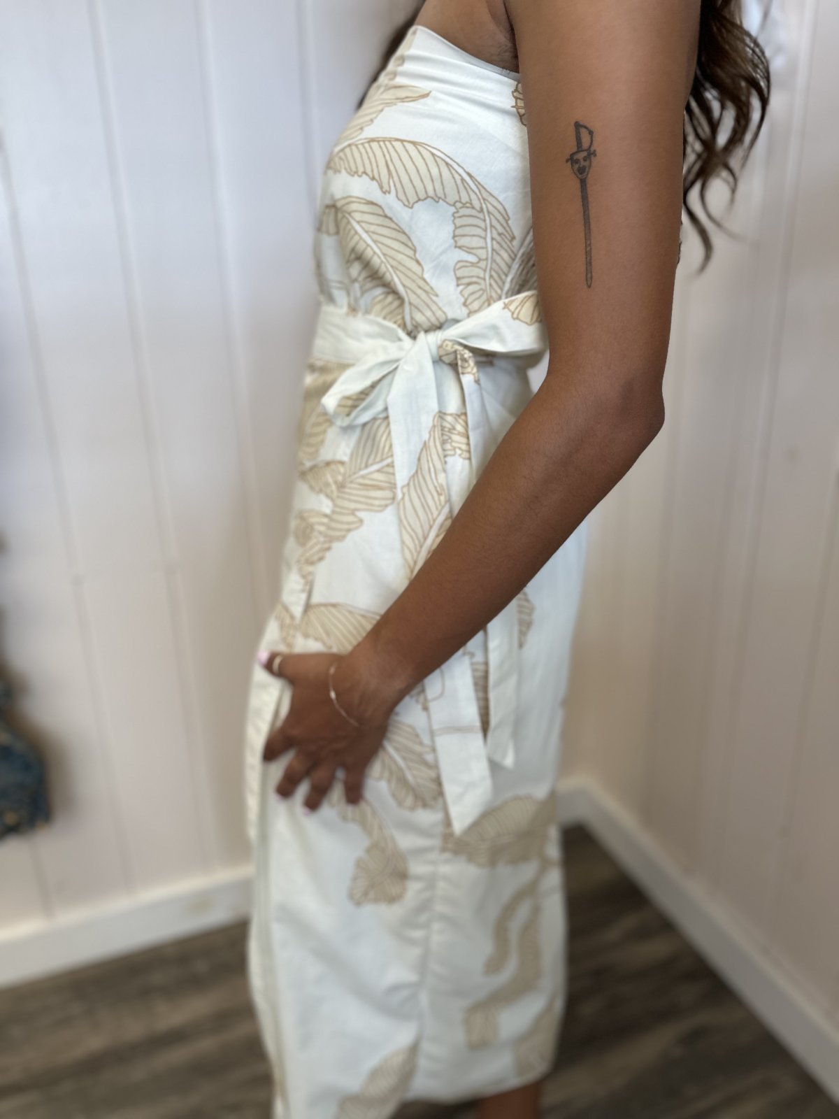 Side view of a stylish strapless white Adele dress with light taupe palm print, perfect for beach outings from a Port Aransas boutique.