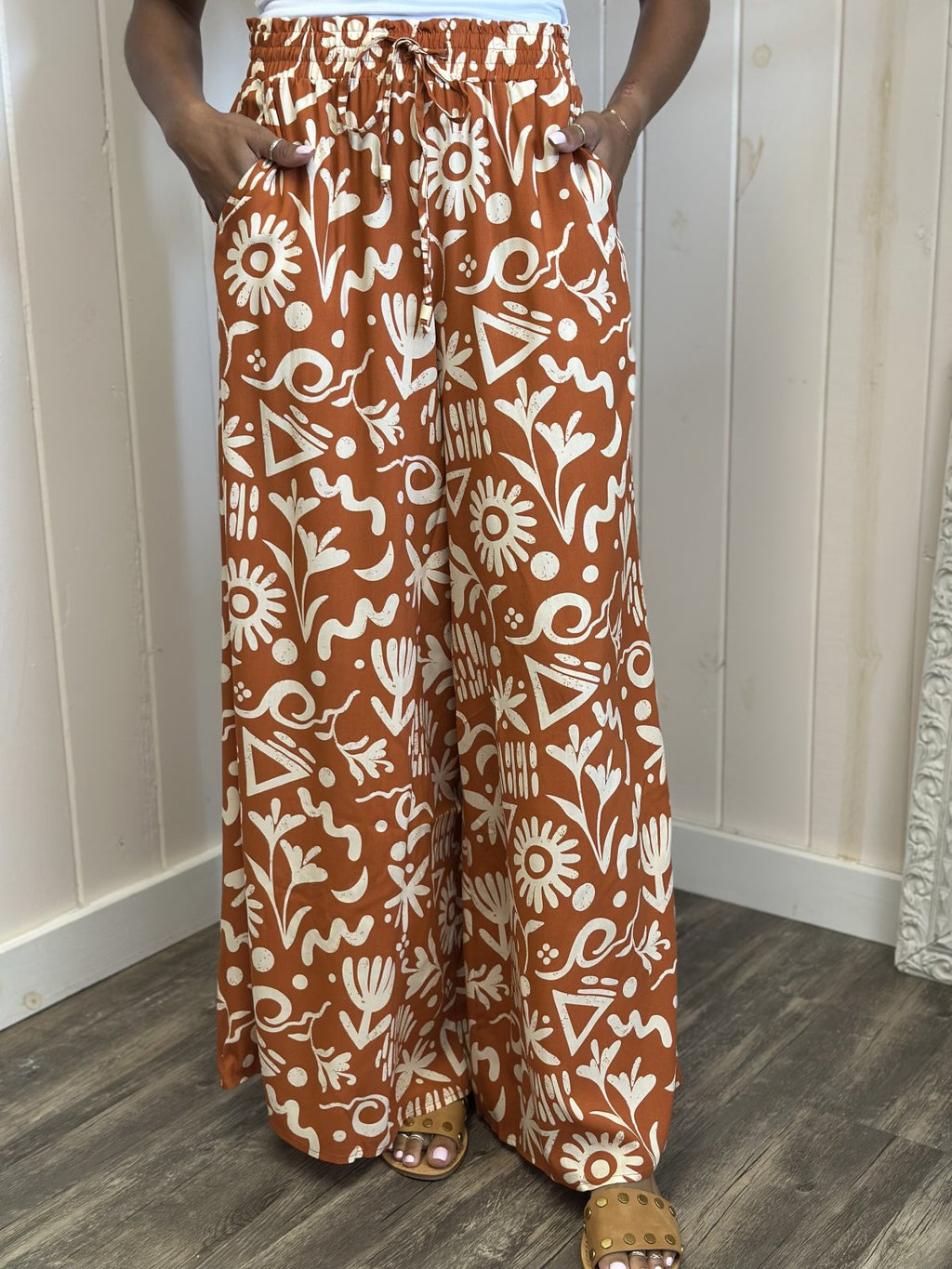 Stylish Sunset Orange wide leg pants with a ruffled elastic waistband, ideal for coastal boutique clothing and beach dresses.