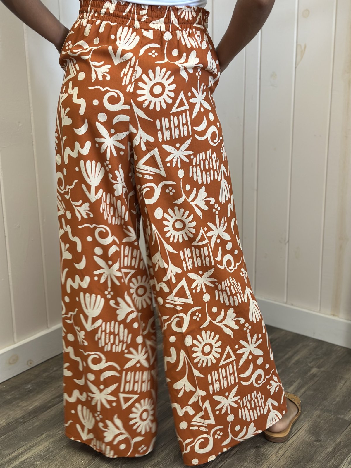 Mila Pants: Vibrant Sunset Orange printed wide leg pants, perfect for coastal boutique clothing and tropical vacations.