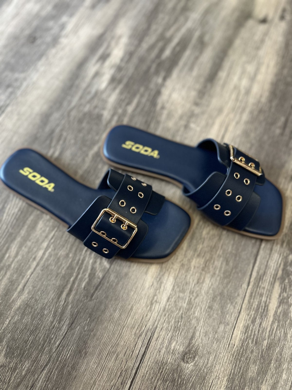 Kendra Navy Slide sandals featuring a stylish buckle design, perfect for coastal boutique clothing and tropical vacation outfits.