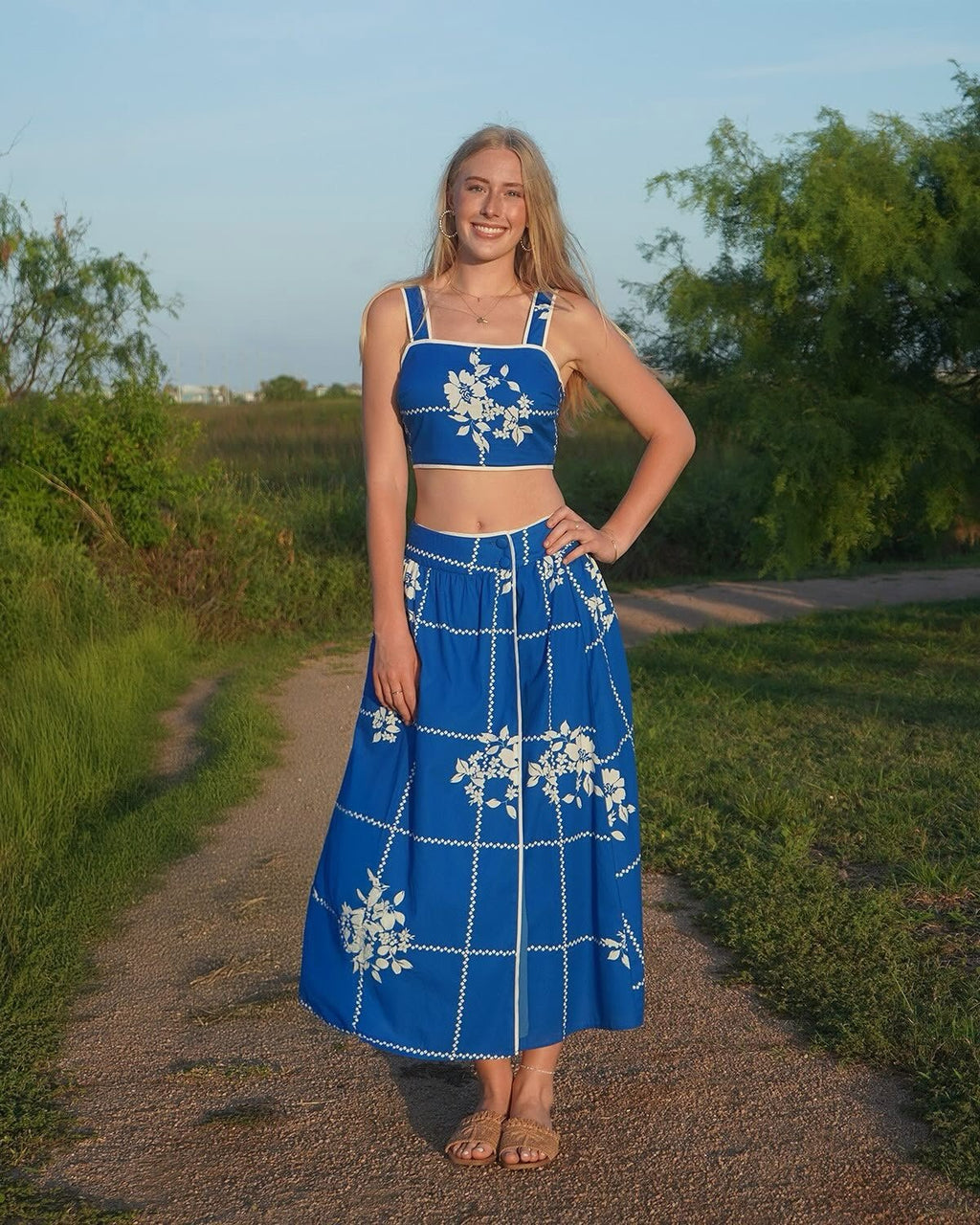 Model wearing a vibrant cobalt blue two-piece dress with floral print, perfect for coastal boutique clothing and beach outings.