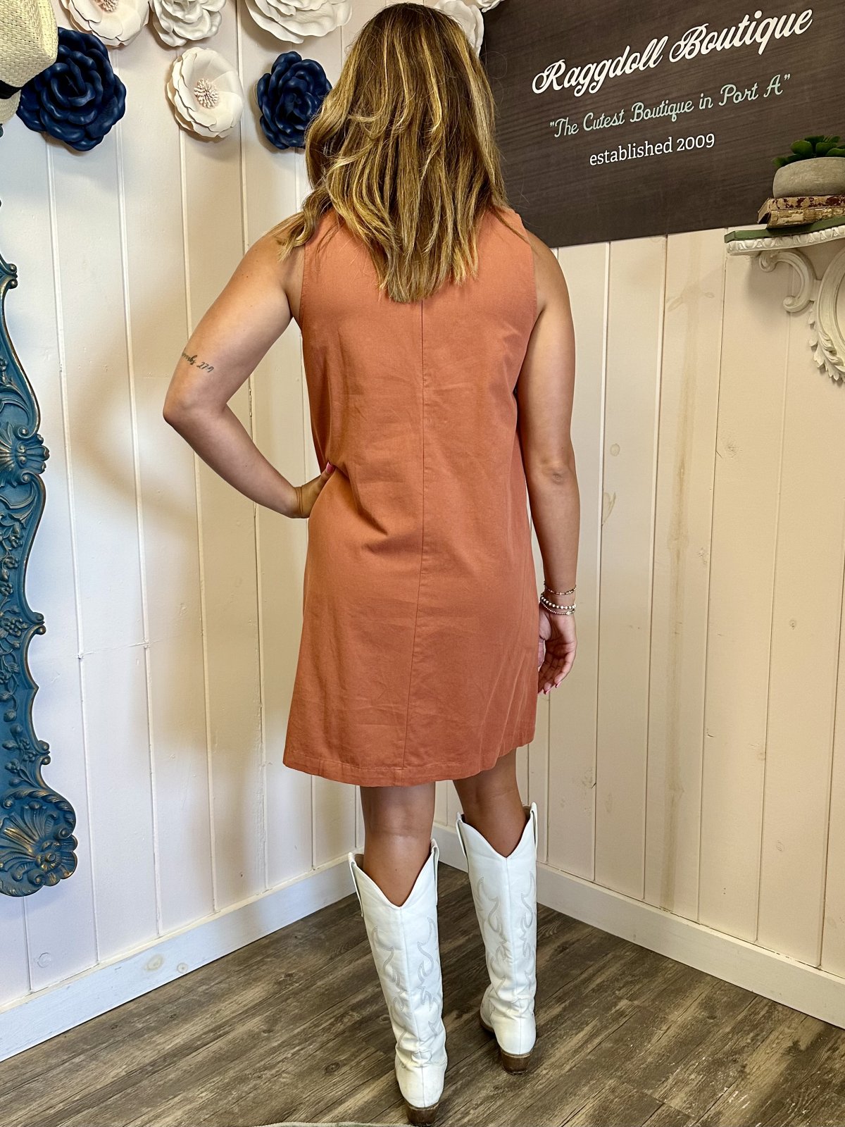 Back view of rust-colored sleeveless denim mini dress, perfect for coastal boutique clothing and tropical vacation dresses.