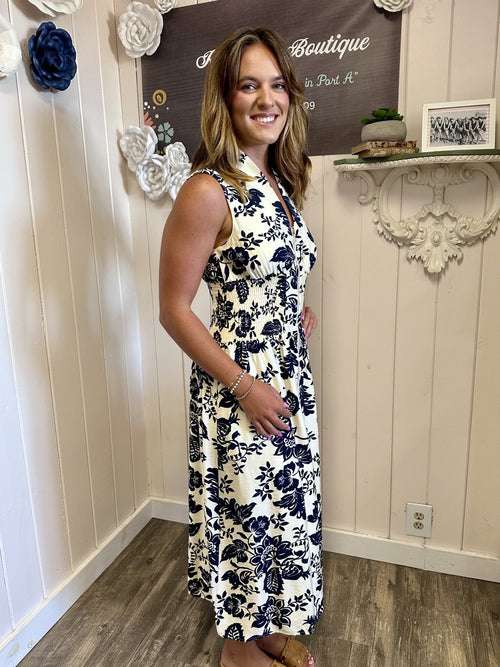 LeAnna Dress worn by a model in Raggdoll Boutique showcasing floral design and navy blue print in Port Aransas.