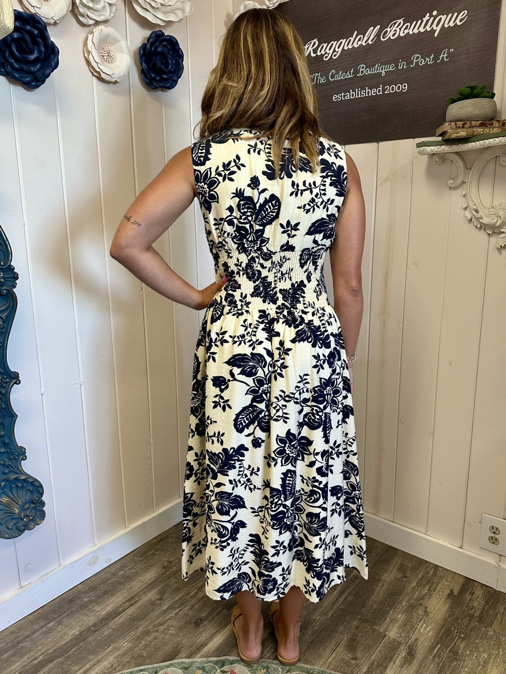 LeAnna Dress displayed at Raggdoll Boutique, showcasing a back view of the floral pattern in navy blue on a lightweight fabric.