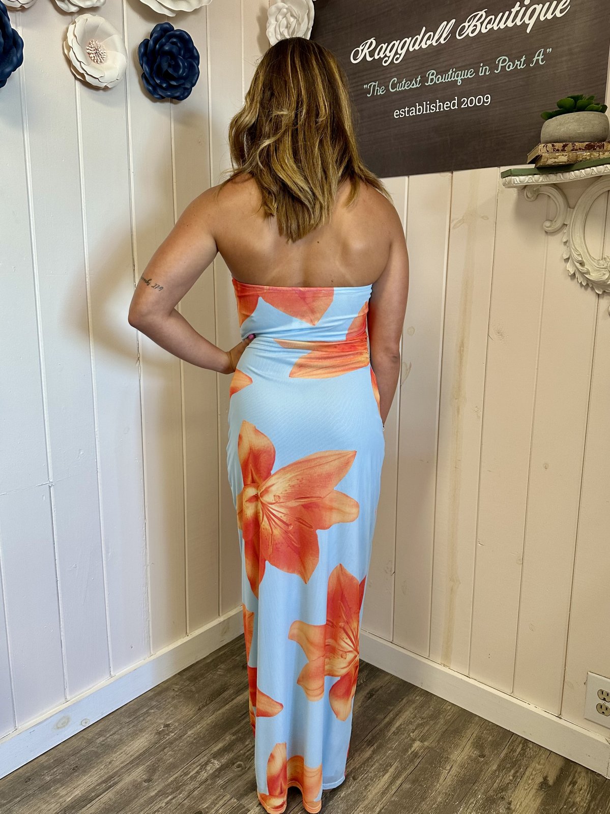 Light blue tropical strapless dress with orange florals, showcased at Raggdoll Boutique in Port A, ideal for beach vacations.