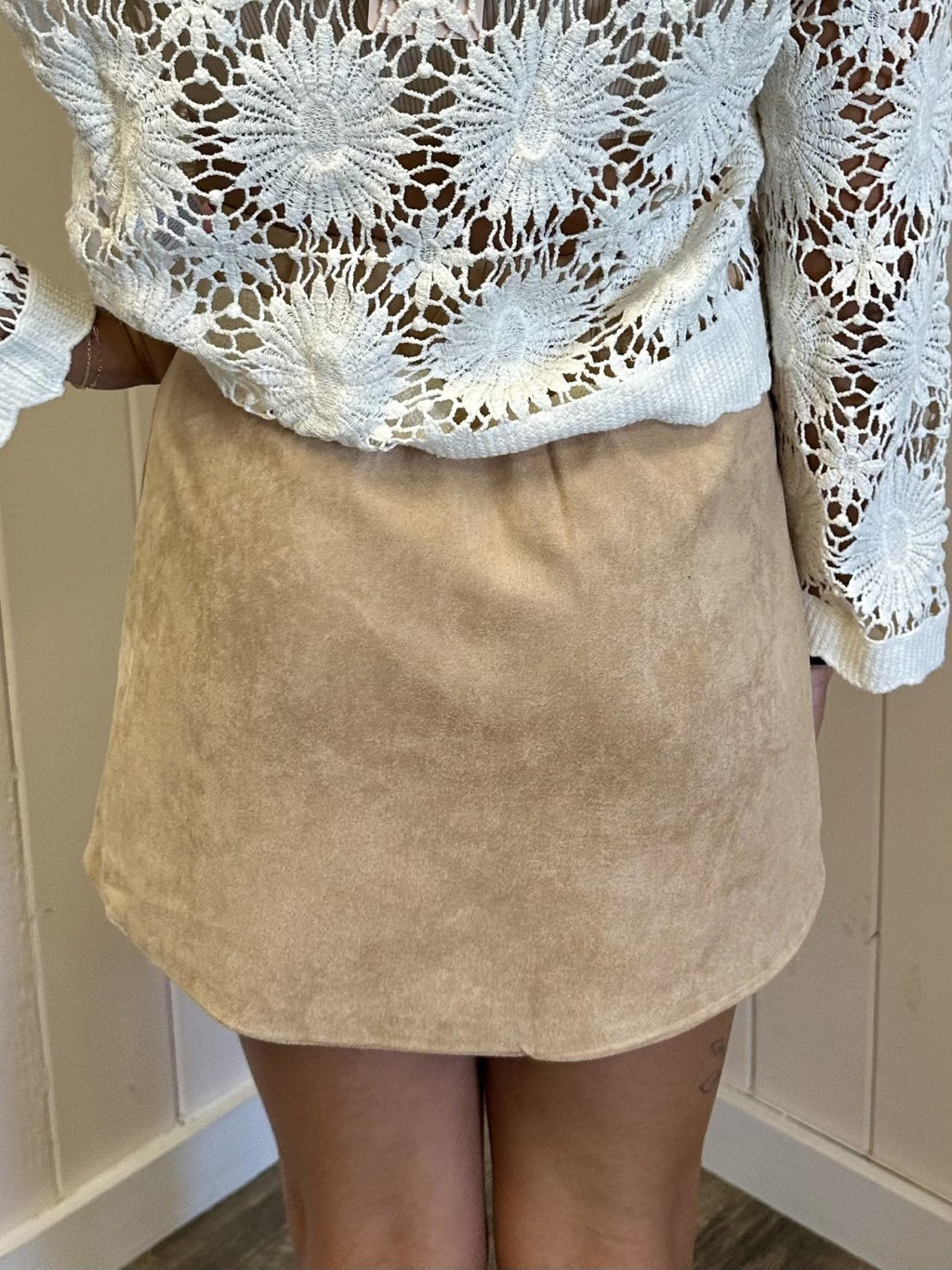Back view of the Mae Skirt in beige suede, styled with a white crochet top for trendy coastal fashion.