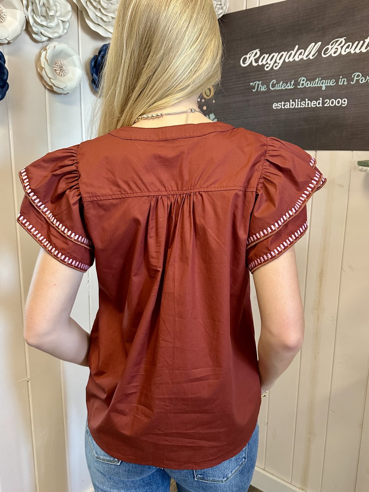 Back view of the Willow Top featuring solid ruffle flutter sleeves and embroidered trim, perfect for trendy coastal style with Raggdoll Boutique.