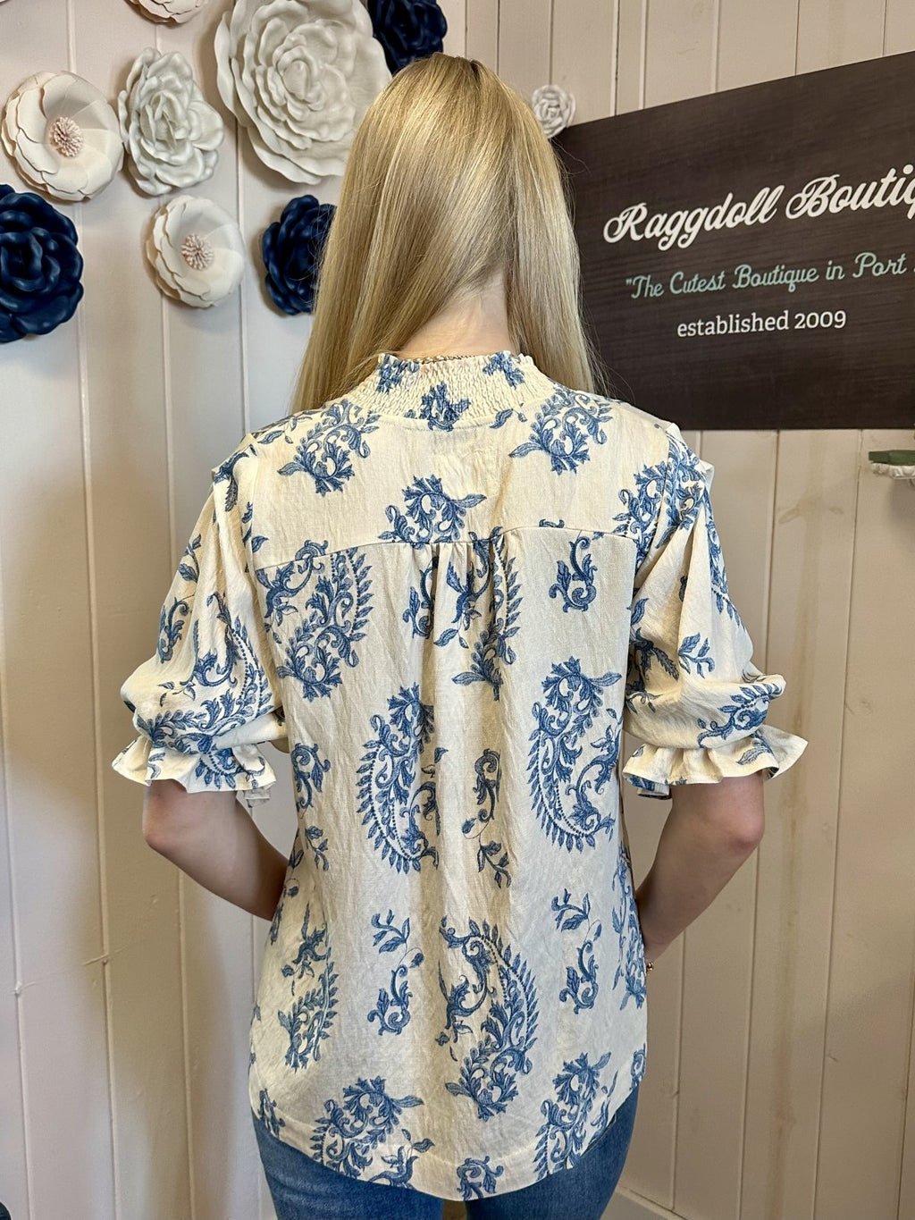 Back view of trendy floral blouse from Raggdoll Boutique, perfect for coastal fashion and summer outfits in Port Aransas.