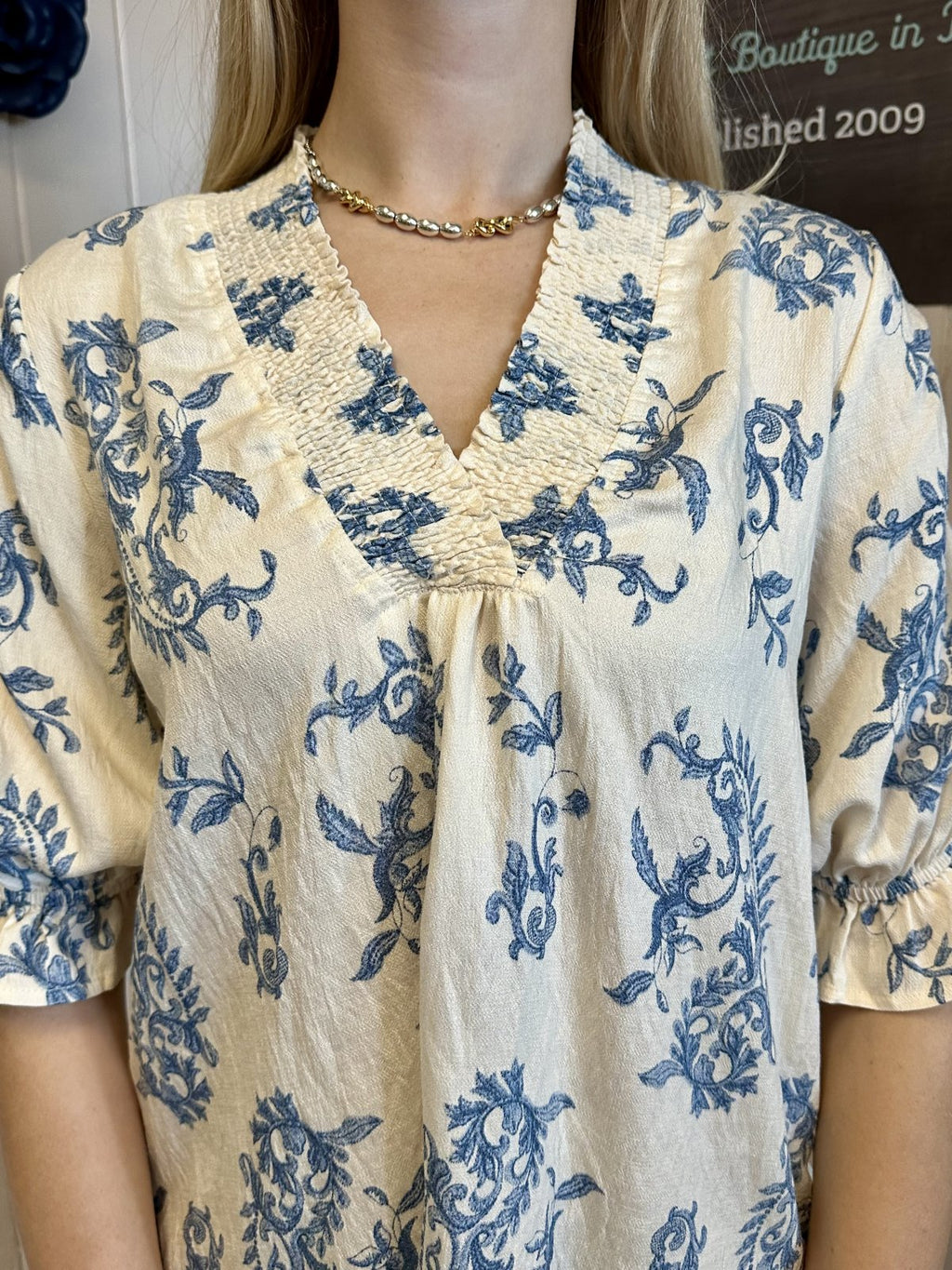 Melody Top featuring a notched V-neckline and ruffle trim, available at Raggdoll Boutique, a coastal fashion boutique.