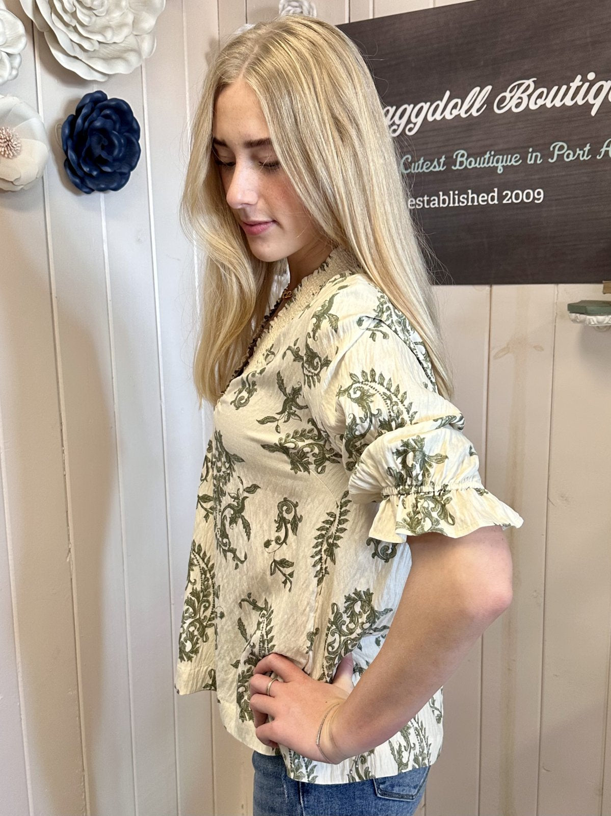 Trendy floral boutique top worn by a model at Raggdoll Boutique, Port Aransas, showcasing coastal fashion style.