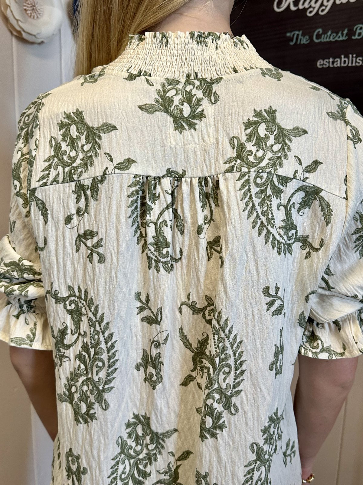 Maddy Top back view featuring botanical print and ruffle details from Raggdoll Boutique, perfect for vacation wardrobe.