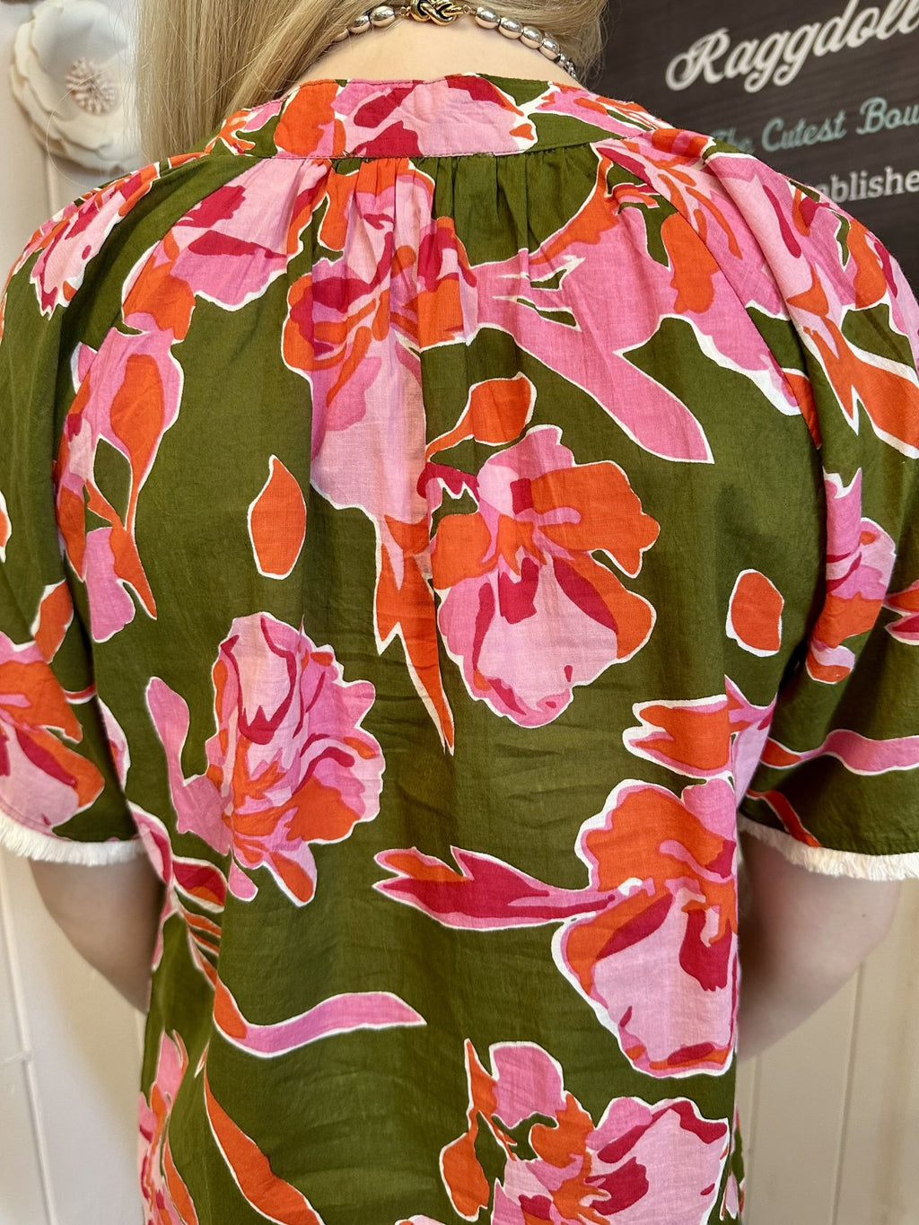 Back view of the Stevie Top featuring pink floral design on olive green, fringe sleeves, available at Raggdoll Boutique.