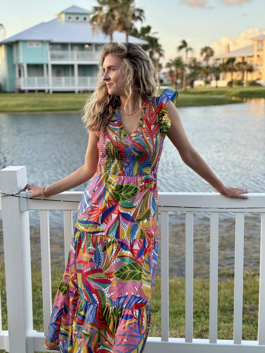 Model in vibrant floral Giselle dress, perfect for coastal boutique clothing and tropical vacation styles.