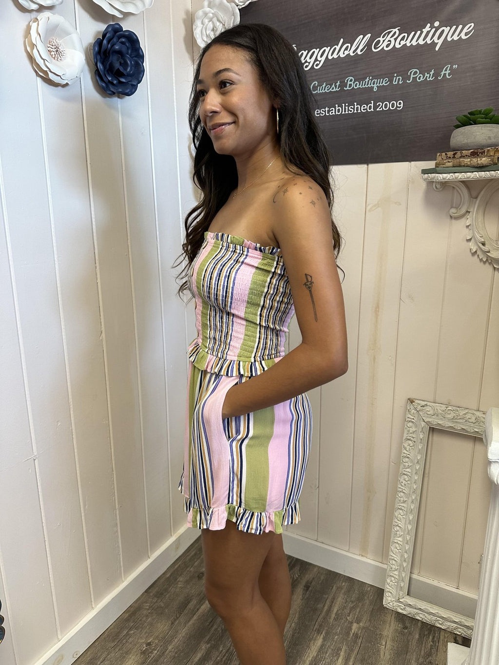 Model wearing a pink multi-striped tube playsuit from a Port Aransas boutique, showcasing coastal fashion vibes.