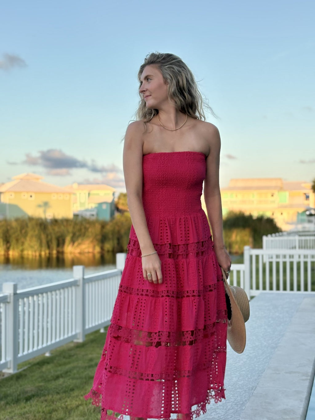 Model wearing the Nixie Dress, a fuchsia eyelet tube strapless midi dress by Raggdoll Boutique, perfect for summer outfits in Texas.
