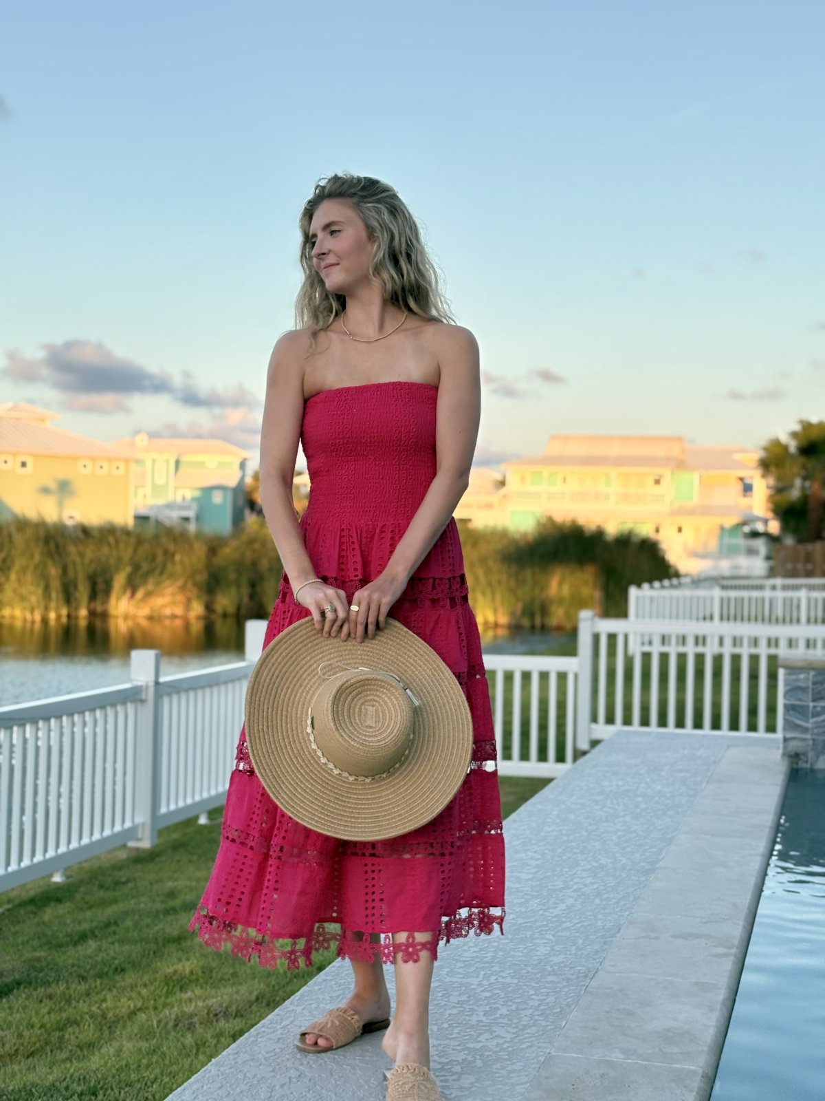 Model wearing the Nixie Dress by Raggdoll Boutique, showcasing trendy coastal style by the water.