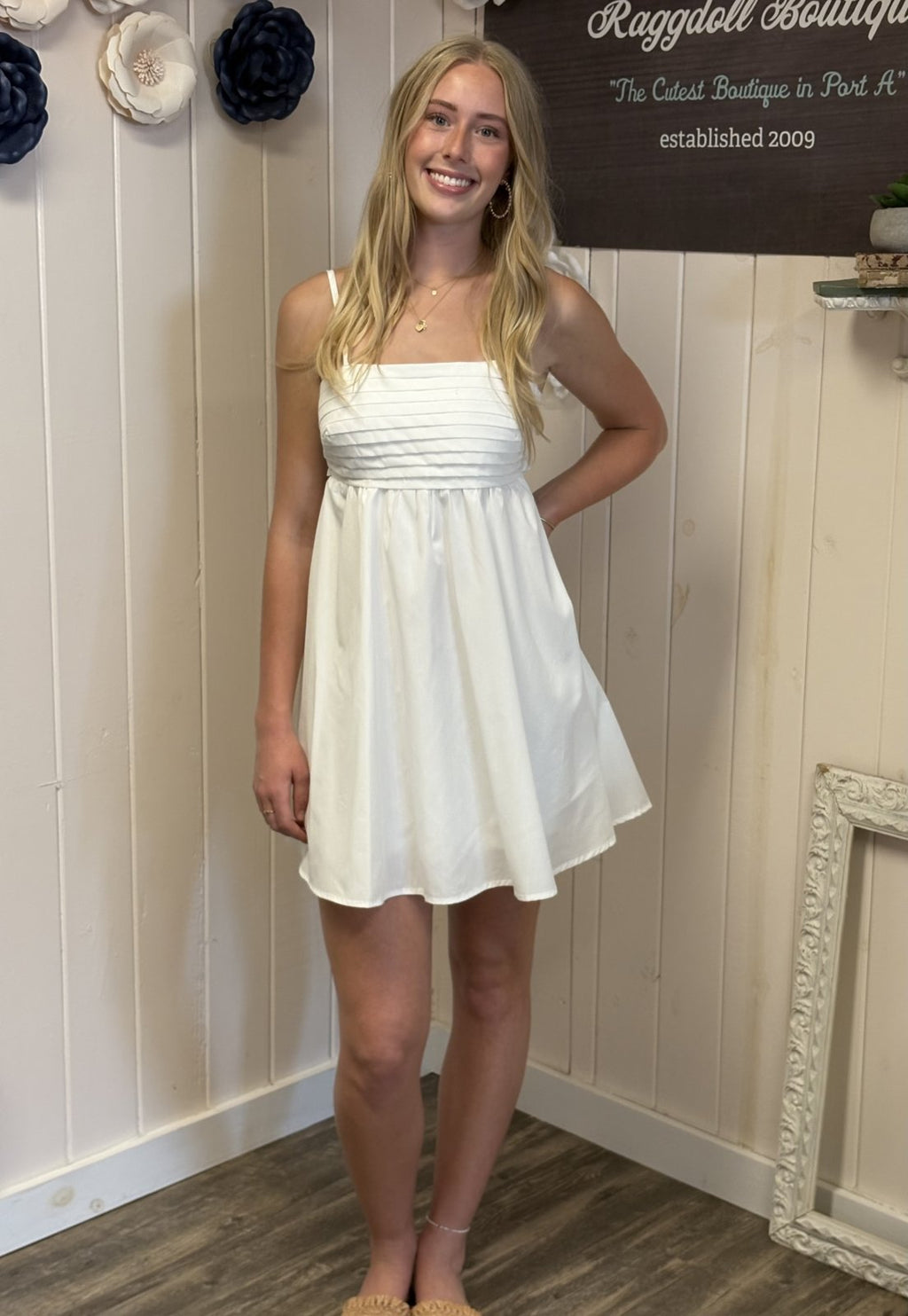 Elegant off-white pleated dress from coastal boutique, perfect for summer outings, bridal showers, and stylish vacations.