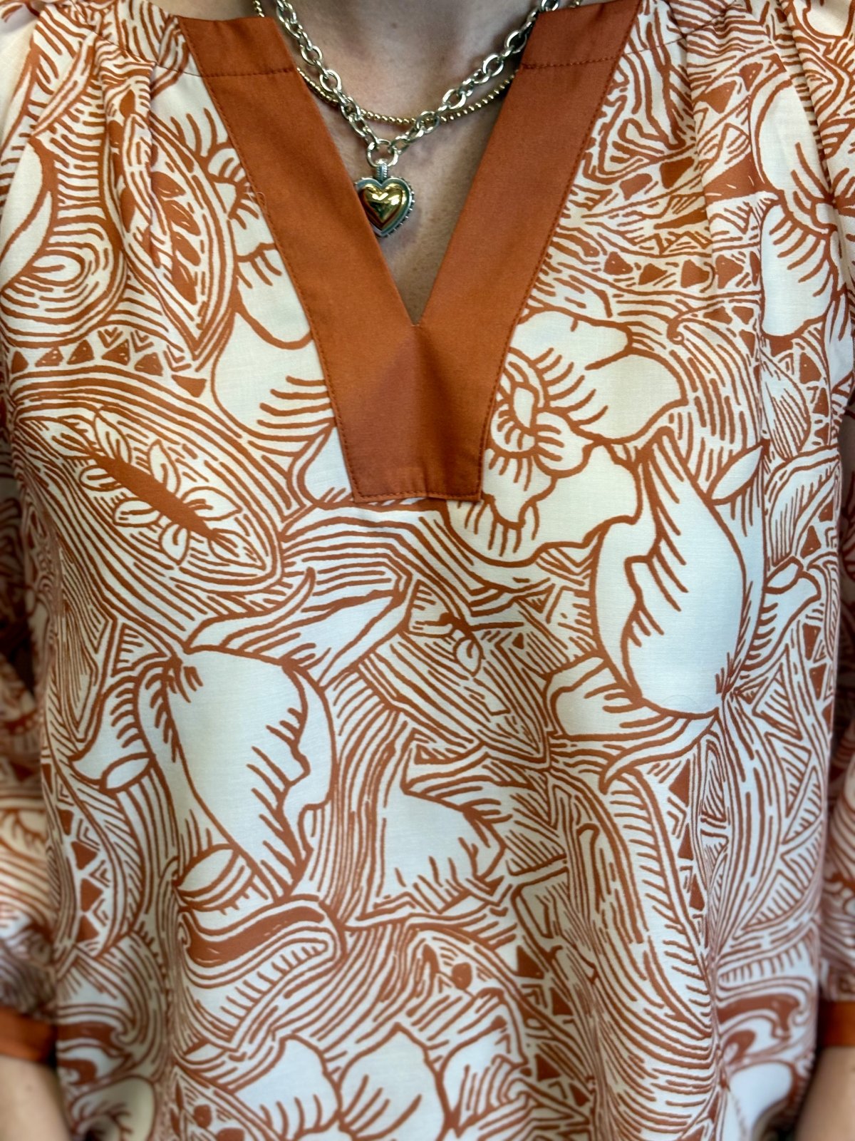 Orange and white floral top with 3/4 sleeves, perfect for game day and stylish coastal fashion from a Port Aransas boutique.