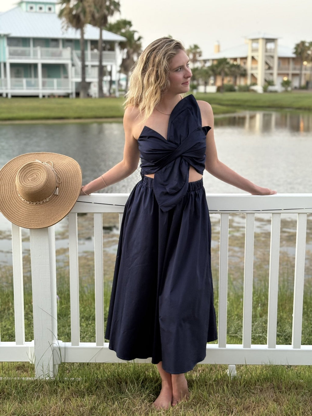 Navy Knot Twisted Midi Dress showcased at a coastal location, perfect for beach dresses and tropical vacations.