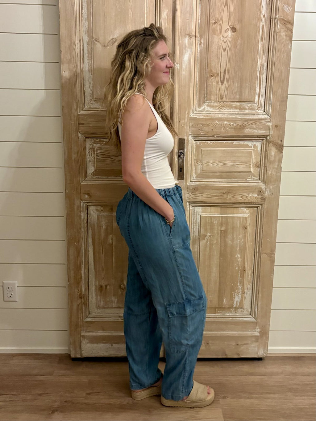 Woman wearing Eliza Pants in medium wash denim, showcasing relaxed-fit style perfect for coastal boutique clothing.
