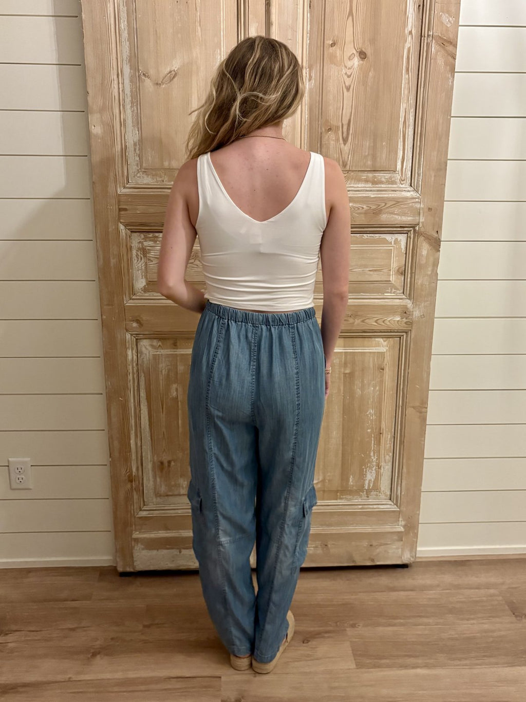 Back view of the Eliza Pants styled with a white tank top, showcasing the relaxed fit and adjustable waistband. Perfect for coastal boutique clothing.