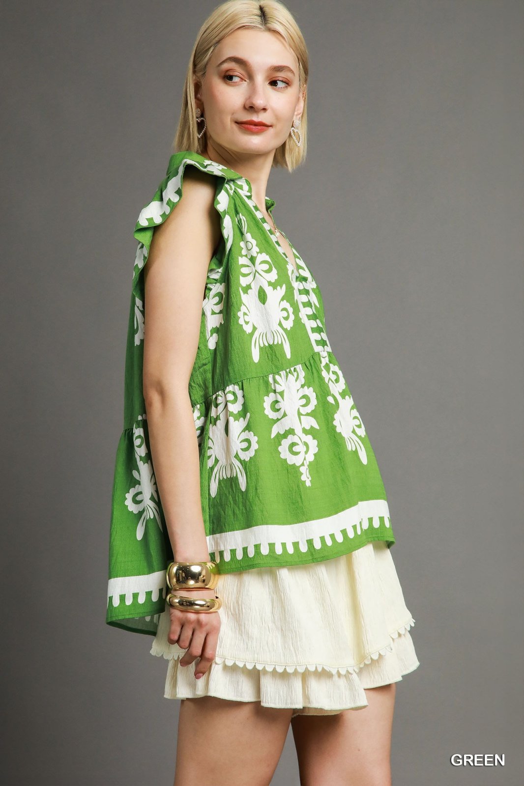 Stylish green peplum blouse with flutter sleeves, perfect for beach days at a Port Aransas boutique.