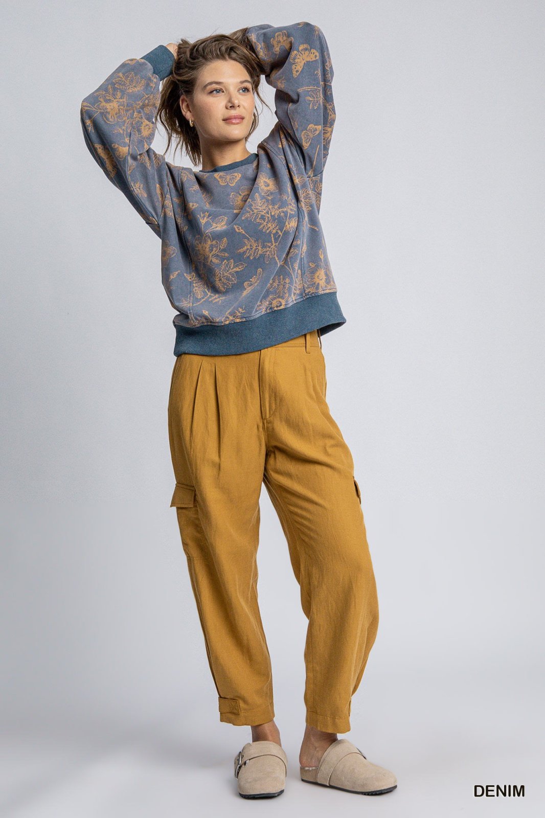 Model wearing a floral French terry top with cargo pants, perfect for coastal boutique clothing and curvy plus size fashion.