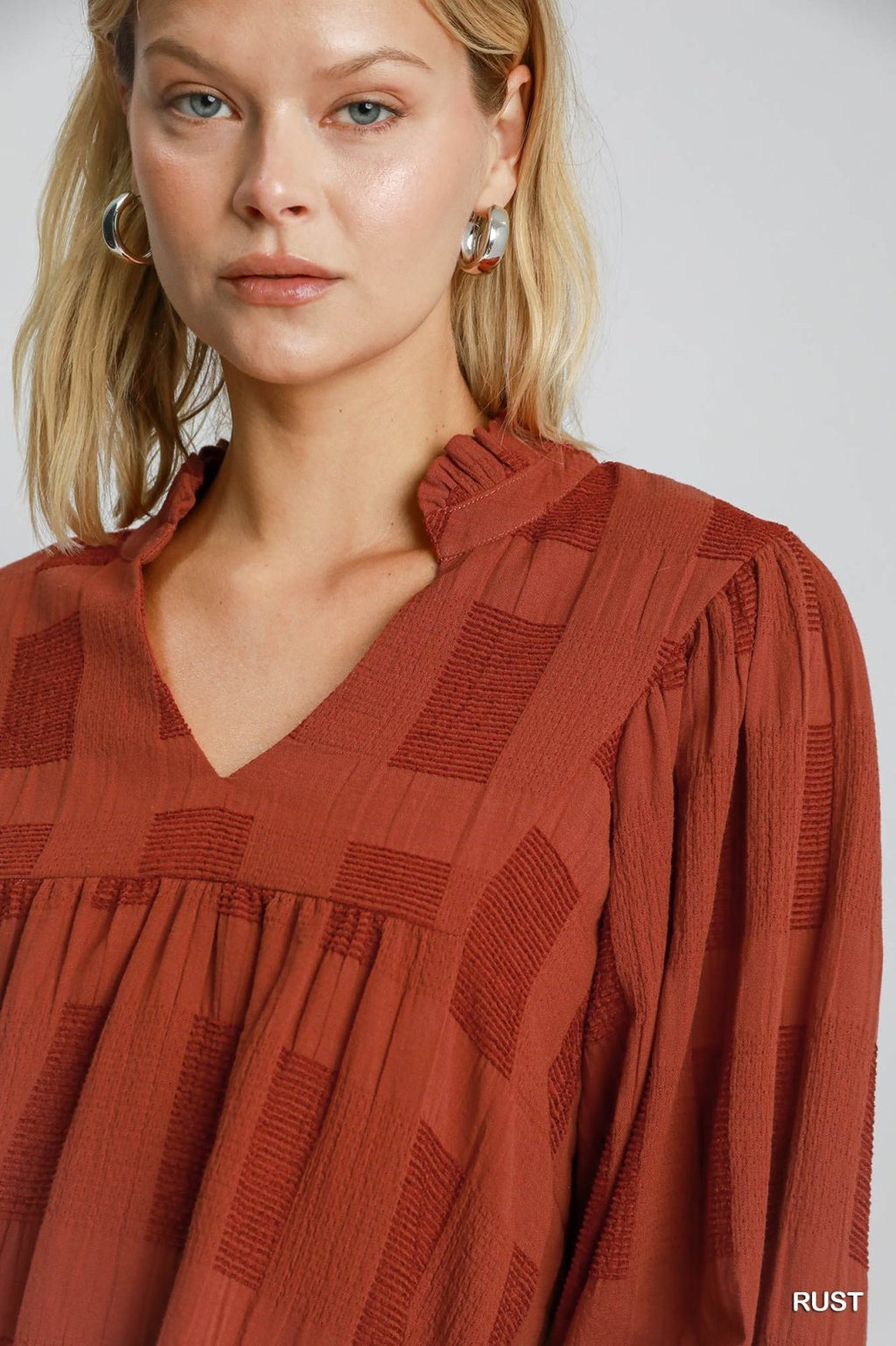 Stylish rust jacquard top from a coastal boutique, perfect for beach dresses and curated women's fashion.