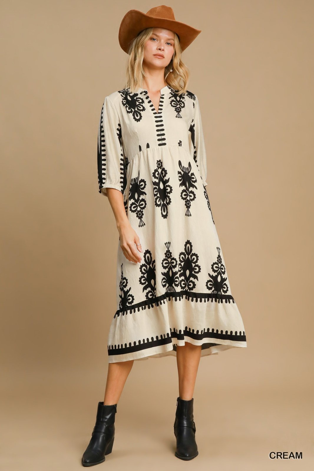 Stylish cream midi dress with black detailing, perfect for coastal boutique clothing and tropical vacation outfits.