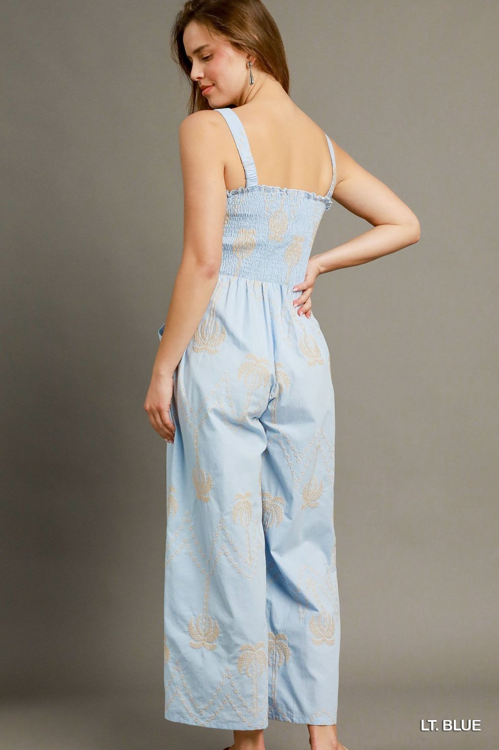 Light blue boho smocked jumpsuit with wide legs from coastal boutique, perfect for beach vacations and summer outings.