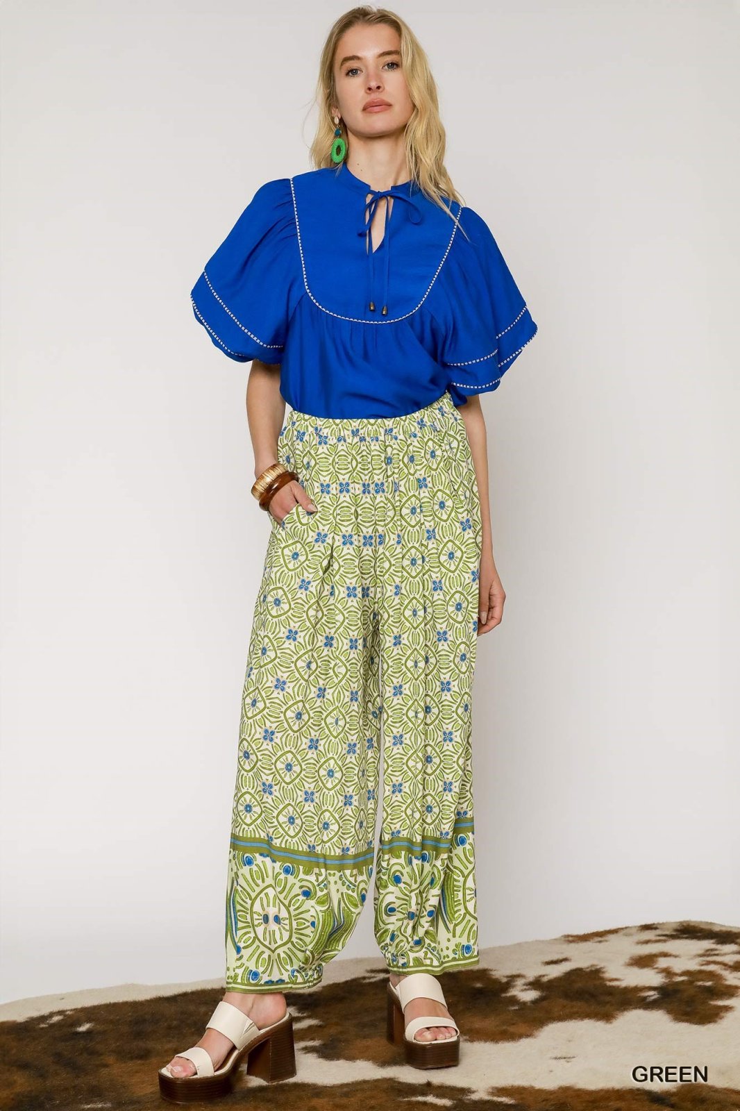 Stylish mixed print green palazzo pants paired with a vibrant blue blouse, perfect for coastal boutique clothing.