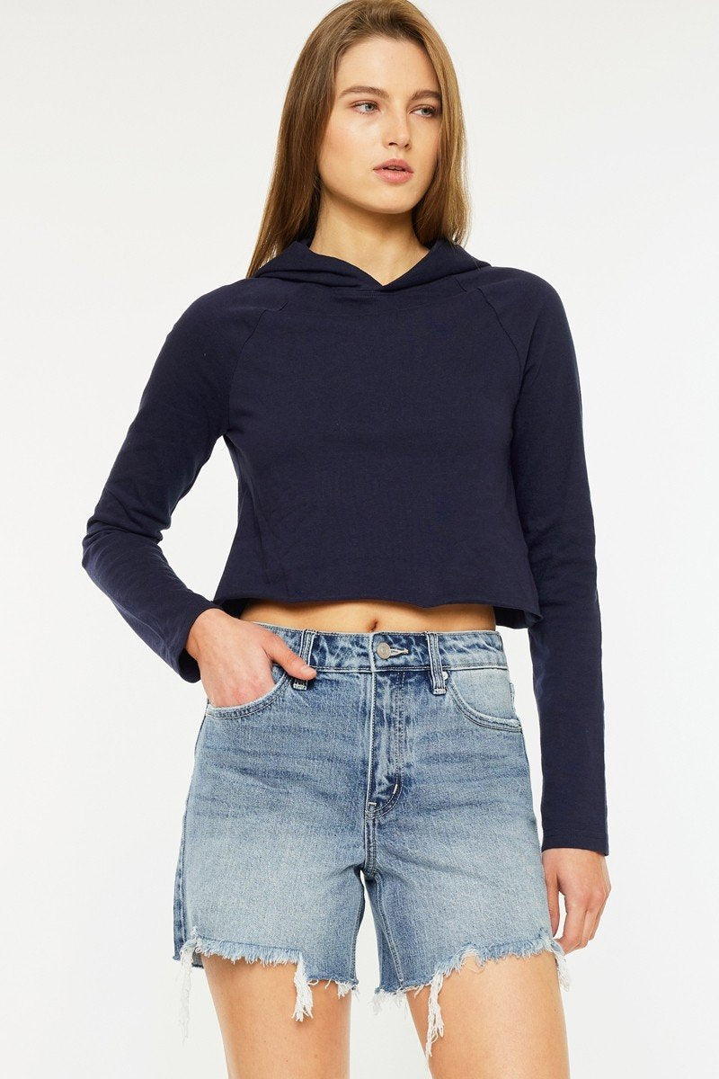 Stylish high-rise denim shorts paired with a cropped navy hoodie, perfect for coastal boutique clothing and summer outfits.