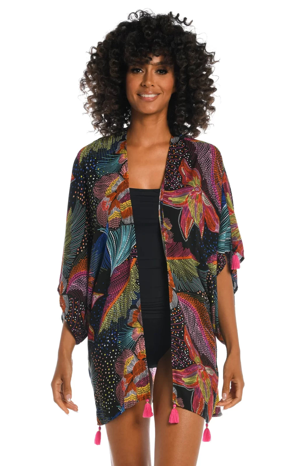 Model wearing SUNLIT SOIREE KIMONO over swimwear, showcasing vibrant colors and trendy coastal style.