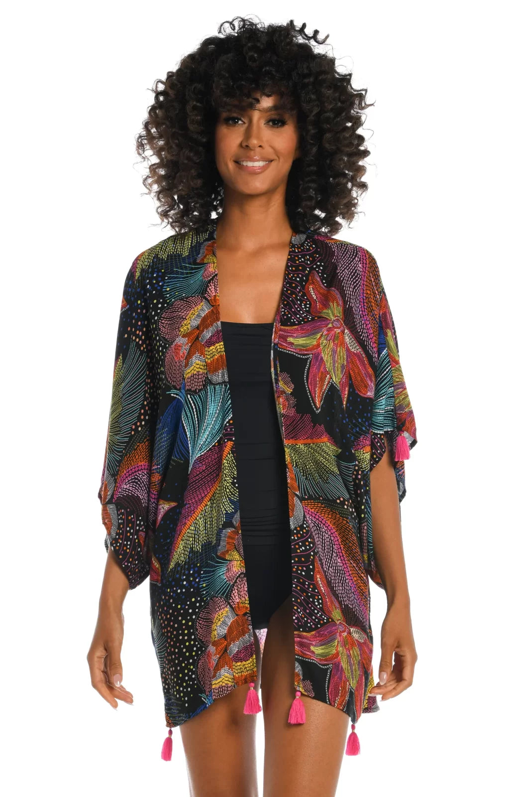 Model wearing SUNLIT SOIREE KIMONO over swimwear, showcasing vibrant colors and trendy coastal style.