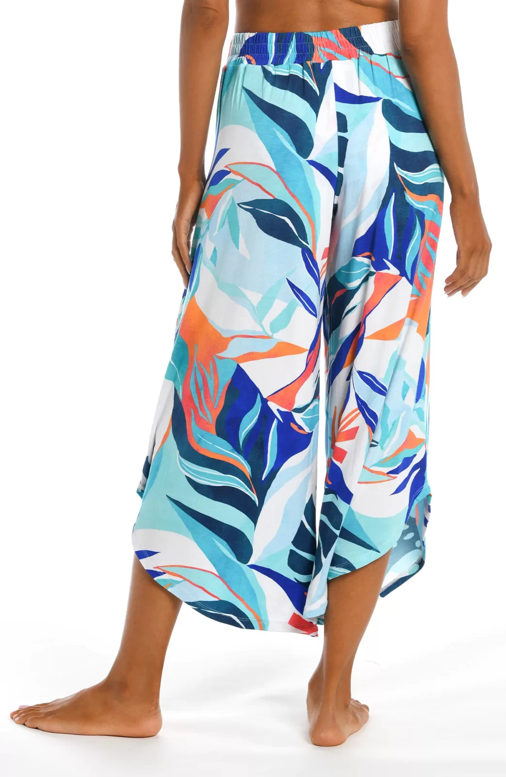 Woman wearing COASTAL PALMS PALAZZO PANTS from Raggdoll Boutique showcasing trendy coastal style.