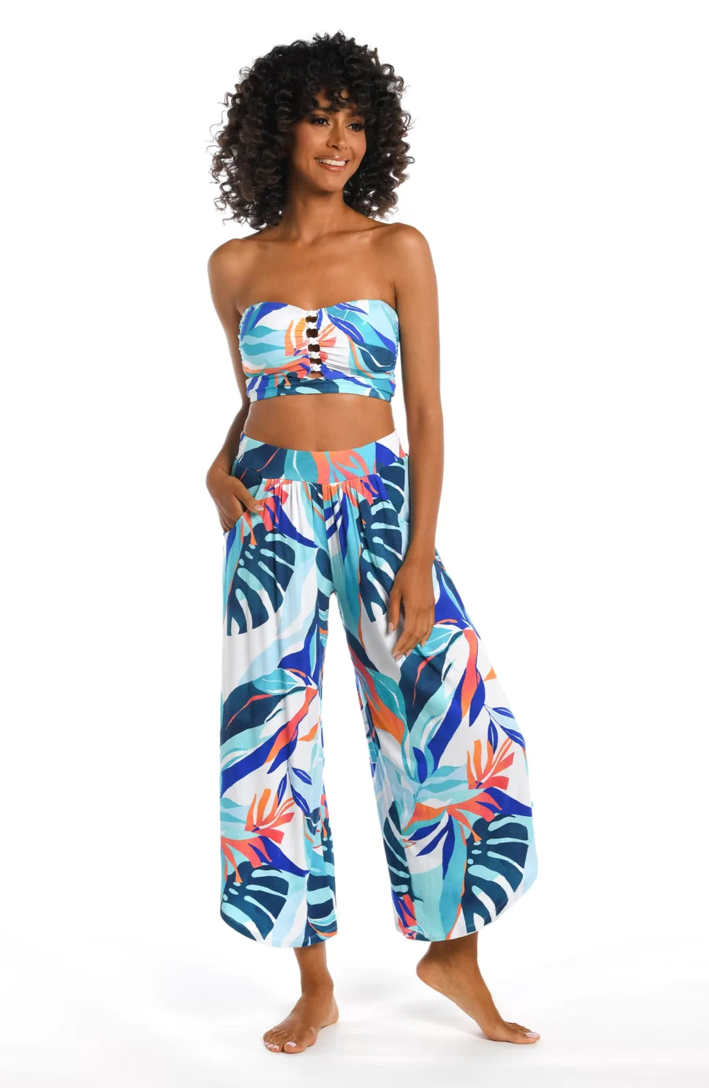 Stylish woman in COASTAL PALMS PALAZZO PANTS from Raggdoll Boutique showcasing trendy coastal style.