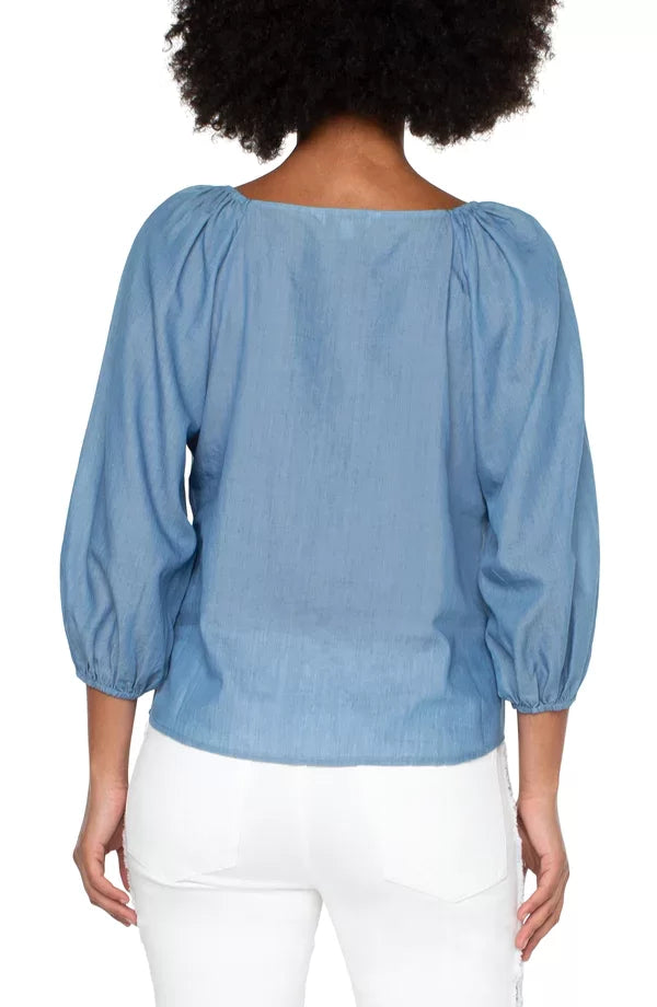 Back view of LIVERPOOL LIGHT CHAMBRAY TOP featuring puff sleeves, perfect for trendy coastal style at Raggdoll Boutique.