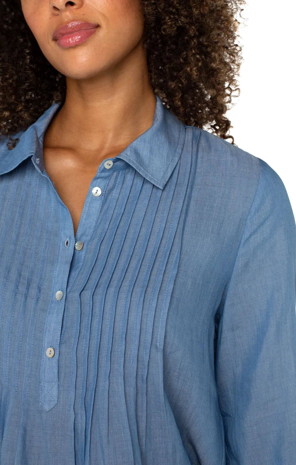 Trendy blue blouse with pleats, perfect for summer outfits at Raggdoll Boutique in Port Aransas.