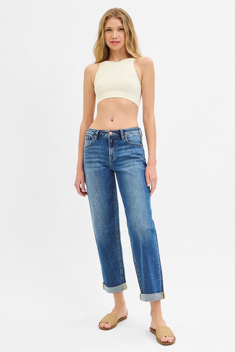 Model wearing Risen Dark Wash Mid Rise Boyfriend Roll-Up Jeans with a cropped top, showcasing relaxed coastal boutique fashion.