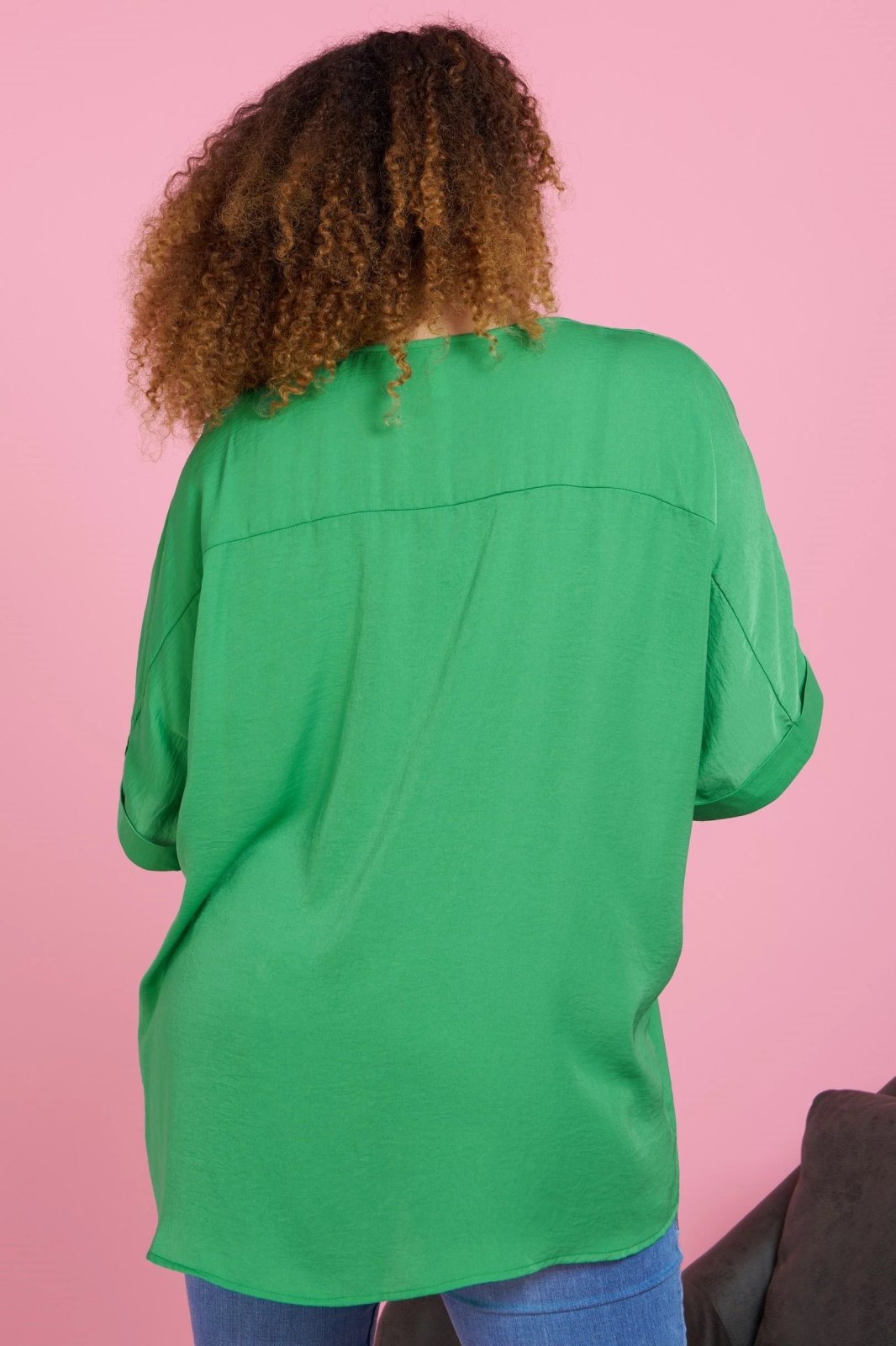 Back view of a woman wearing a PLUS KELLY GREEN SATIN TOP from Raggdoll Boutique, showcasing trendy coastal style.